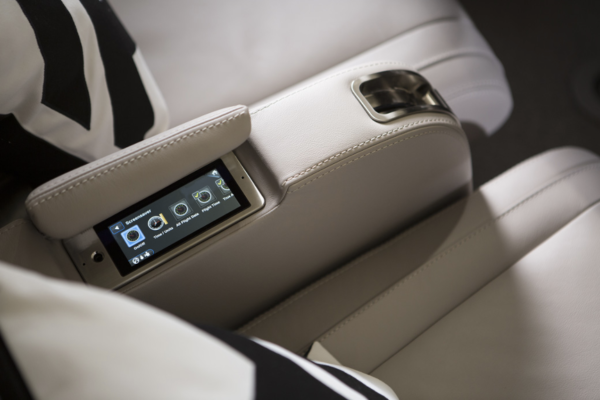 Armrest of a beige, leather-upholstered seat with built-in touchscreen control system. The touchscreen shows options for “On/Off,” “Time/Units,” “All Flight Data” and “Flight Time.”