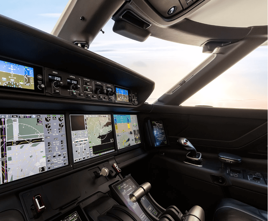 Side angle view of the Gulfstream G500’s cockpit, with a row of display screens and controls.